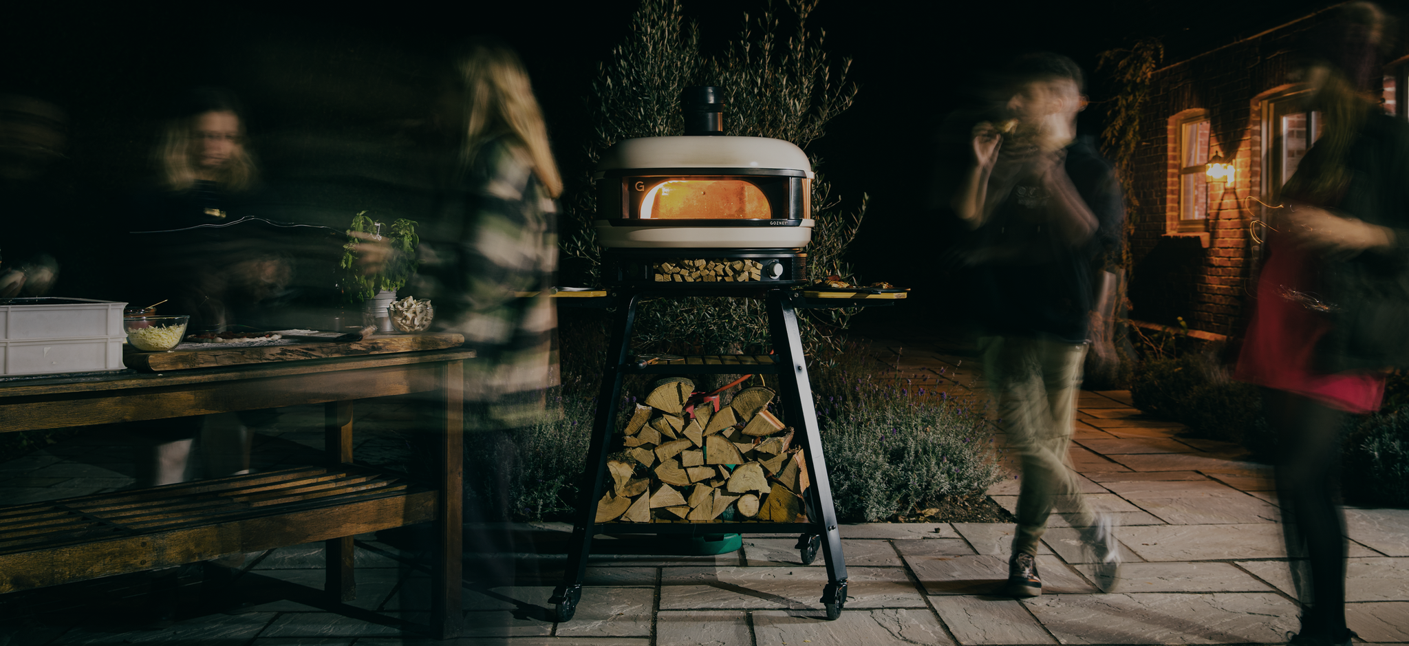 Pizza part at night with lit pizza oven