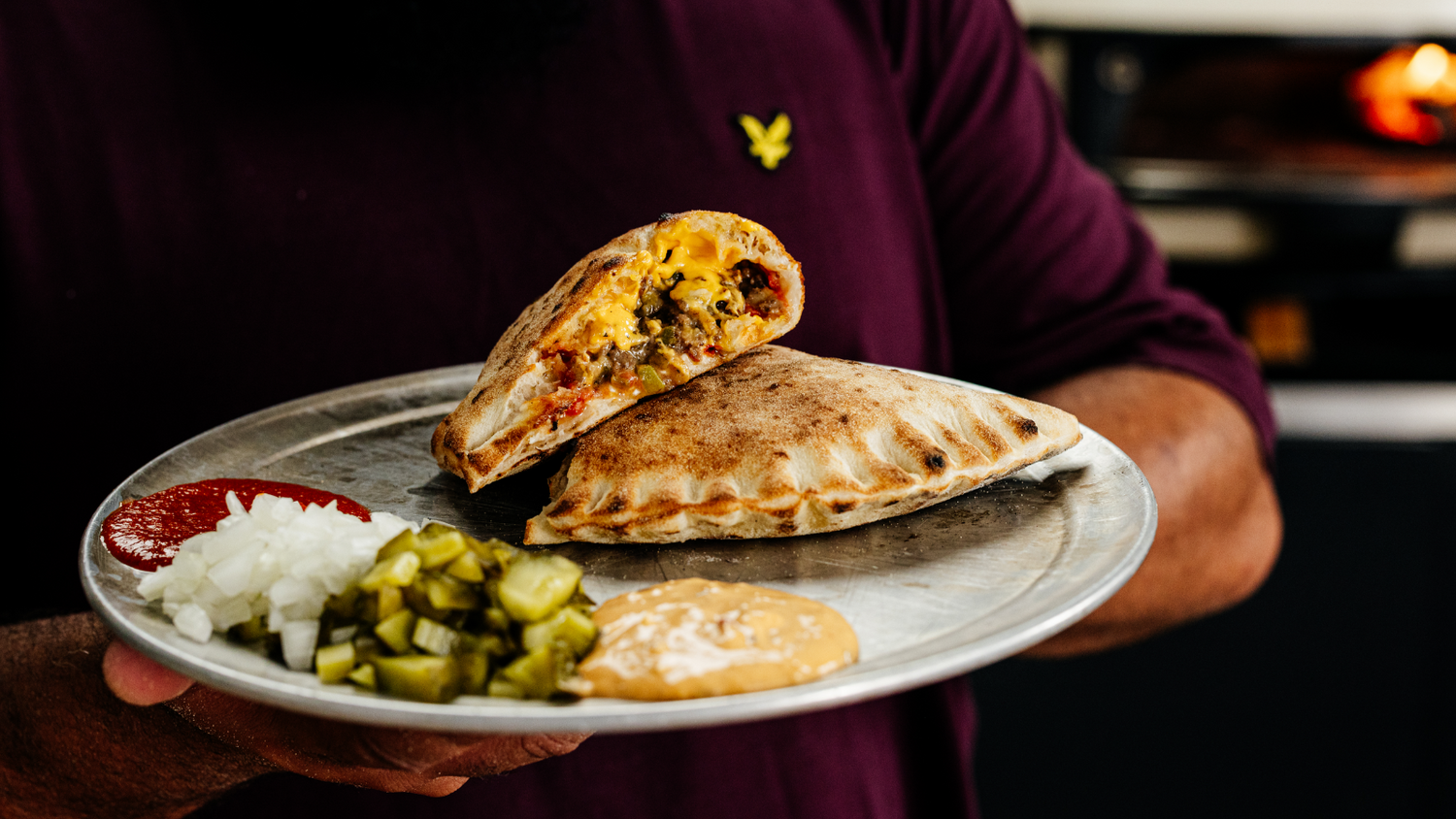 Chopped Cheese Calzone stacked on a plate. recipe poster image