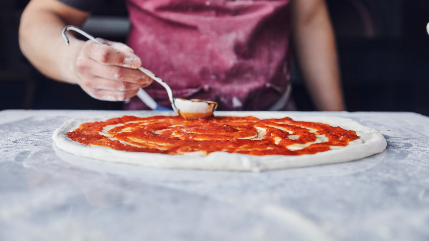 Marinara Sauce spread on a pizza dough base